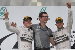 Hamilton (right) and Rosberg take 1-2 places in the Malaysian GP on Sunday as they pose with their engineer (centre). A Mercedes photo