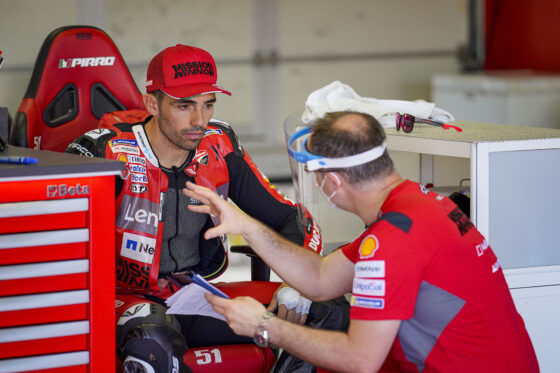 A team engineer talks to Michele Pirro, test rider, at Misano on Thursday with protective gear. A Ducati image